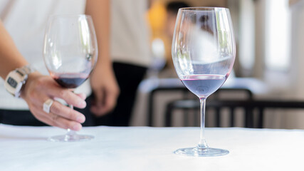 A glass of wine on the table and another glass with a handle on the celebration.