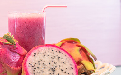 Pitaya juice and fruits (Hylocereus guatemalensis, H.undatus) in white tray on pink background