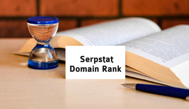 Domain rank business concept text on a white background with a hourglass and an open book