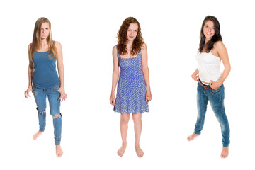 Full length portraits of three beautiful girls wearing casual clothes, isolated on white background