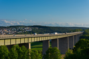 German Autobahn bridge for the highway A3 over the danube river near Regensburg with moving cars in golden afternoon light on clear summer day