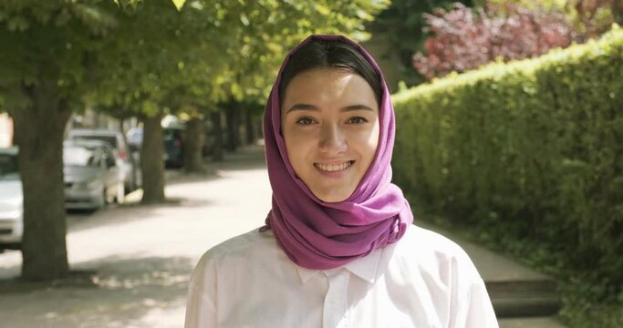Beautiful young woman walk at the street, wearing traditional headscarf. Attractive Female in hijab