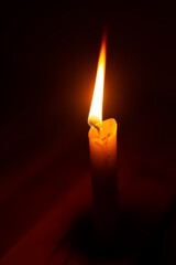 One candle light burning on wood floor and wood background