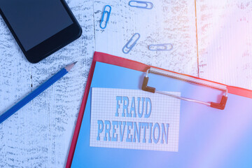 Handwriting text writing Fraud Prevention. Conceptual photo to secure the enterprise and its processes against hoax Clipboard paper sheet pencil note clips smartphone old wooden background