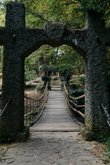 Fototapeta premium Suspension bridge with bamboo railing in a green summer park