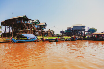 Fototapeta na wymiar Tonle Sap lake. Kampong Phluk floating fishing village during drought season. Houses on stilts, people and boats. Poor country. Life and work residents Cambodian on water, near Siem Reap, Cambodia
