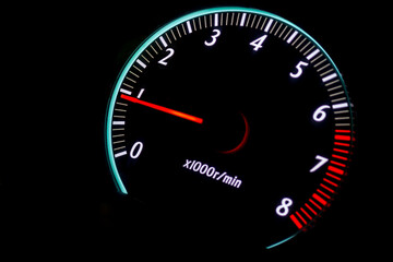 car tachometer with red arrow on black background