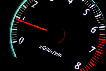 car tachometer with red arrow on black background