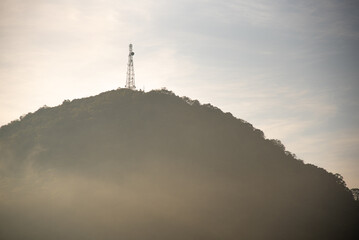 Telecommunications antenna on top of a mountain shrouded in fog