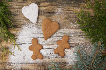 Family love Christmas homemade gingerbread sprinkled with powdered sugar on a wooden background