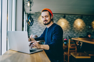 Positive caucasian male checking news from networks working remotely on publicity area, man...