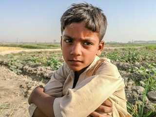 sad homeless boy sitting outdoor cause of poverty 
