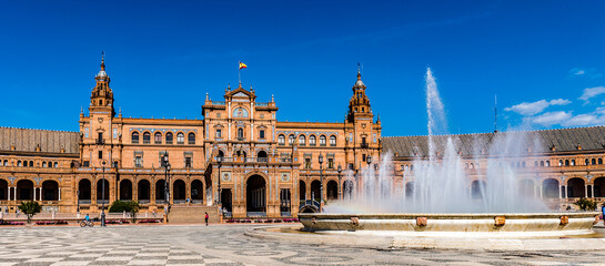 Fototapeta na wymiar It's Central building and the fountain at the Plaza de Espana in Seville, Andalusia, Spain. It's example of the Renaissance Revival style in Spanish architecture.