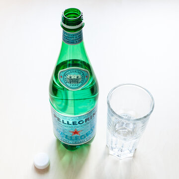 MOSCOW, RUSSIA - JUNE 16, 2020: open bottle of S Pellegrino and glass with water on table. S.Pellegrino is an Italian natural mineral water from San Pellegrino Terme near Bergamo, Lombardy, Italy