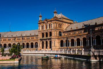 Obraz na płótnie Canvas It's River with boats near Central building at the Plaza de Espana in Seville, Andalusia, Spain. It's example of the Renaissance Revival style in Spanish architecture.