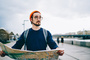Amazed male tourist in trendy glasses for eyes protection surprised with international solo...