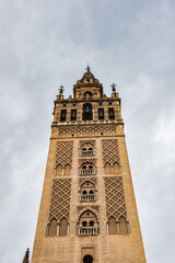 Fototapeta na wymiar It's Giralda, a former minaret that was converted to a bell tower for the Cathedral of Seville in Seville. UNESCO World Heritage