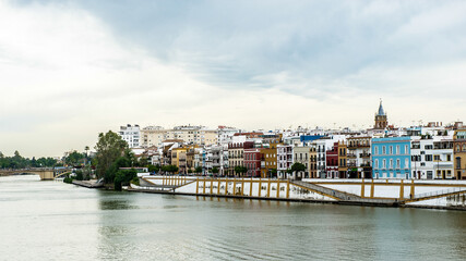 Fototapeta na wymiar It's Guadalquivir river coast and architecture of Seville, Andalusia, Spain.
