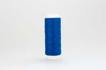 spool of blue thread on a white background