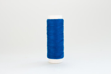 spool of blue thread on a white background