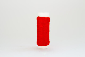spool of red thread on white background