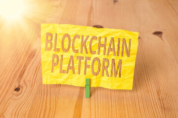 Conceptual hand writing showing Blockchain Platform. Concept meaning thing with a scripting language that solves many cases Wooden floor background green clothespin groove slot office