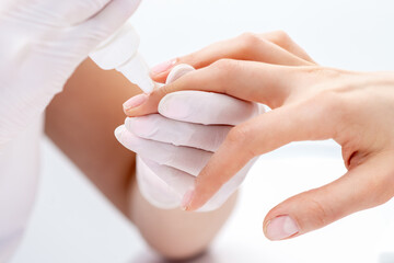 Manicure specialist applying glue for nail of woman close up. Manicurist uses manicure tool.