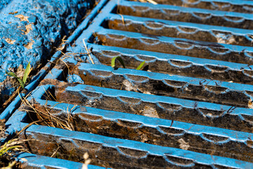 close up blue sewage grill and plants.