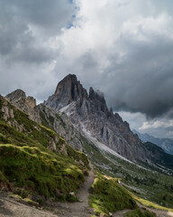 Dark clouds heralding a storm in the Dolomites, a soaring mountain lit by the setting sun.