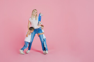 Beautiful blonde mom with two happy sons. Young woman and two baby boys,