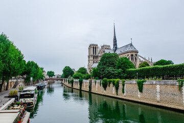 Fototapeta na wymiar The Notre Dame along the Seine River, on a cloudy day, in Paris, France.