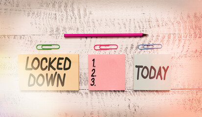 Text sign showing Locked Down. Business photo text emergency measure which showing prevented from restricted area Multicolor blank notepads clips marker pencil wooden vintage background