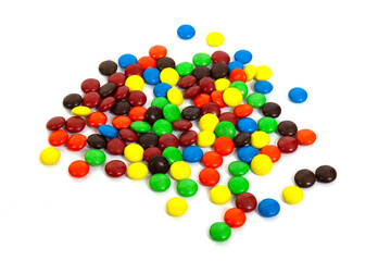 Colorful chocolate M&Ms in and out of focus on white background.