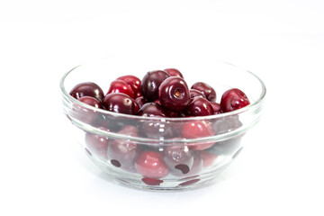 Healthy ripe cherrys in a glass bowl close up shot on white background.