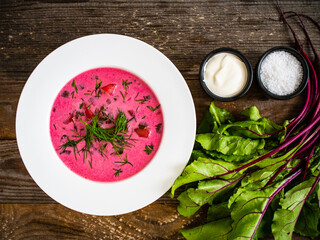 Borsch - beetroots soup with cream on wooden table
