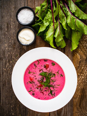 Borsch - beetroots soup with cream on wooden table
