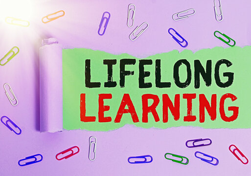 Text sign showing Lifelong Learning. Business photo showcasing pursuit of knowledge for an individualal or professional reasons Rolled ripped torn cardboard placed above a wooden classic table