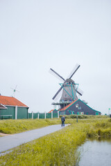 Windmills in Zaanse Schans village, near the sea coast, on a cloudy day.