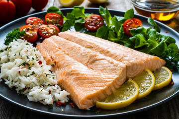 Steamed salmon fillet with basmati rice vegetables on wooden table