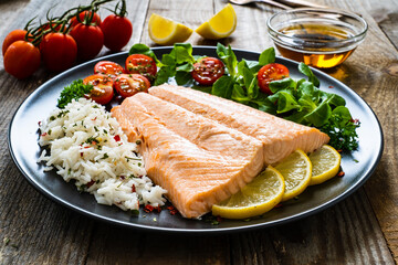 Steamed salmon fillet with basmati rice vegetables on wooden table
