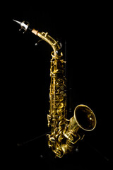 a complete view of a gold saxophone with mechanisms and buttons, an elegant and complex but beautiful wind instrument
