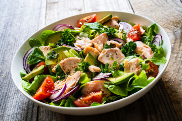 Salmon salad - roasted salmon and vegetables on wooden background
