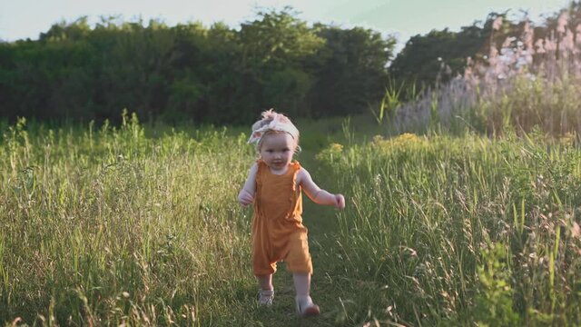 Child toddler girl walking outdoor family vacations traveling happy smiling emotions summer season grass nature                                               