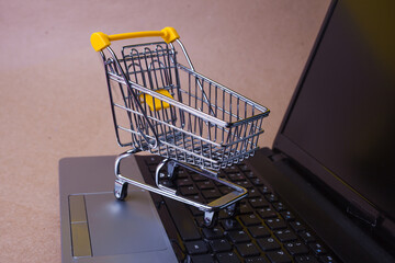 E-Commerce. Online shopping, shopping cart on laptop keyboard.