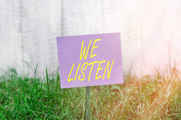 Writing note showing We Listen. Business concept for an organization willing to pay attention by...