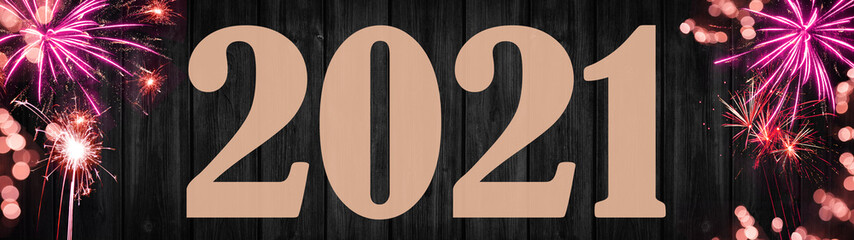 HAPPY NEW YEAR 2021 - Festive silvester background panorama banner long - Pink firework and sparkler on black wooden wall texture with bokeh lights and space for text