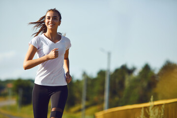 Girl runner runs along the road
