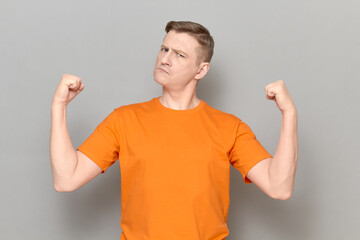 Portrait of proud and rebellious mature man raising clenched fists up