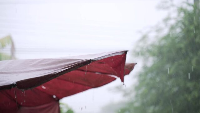 Heavy rain from tropical storm hitting a big garden umbrella