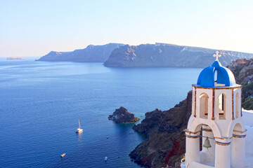 Fototapeta na wymiar A blue domed church on the coast in Santorini, Greece.